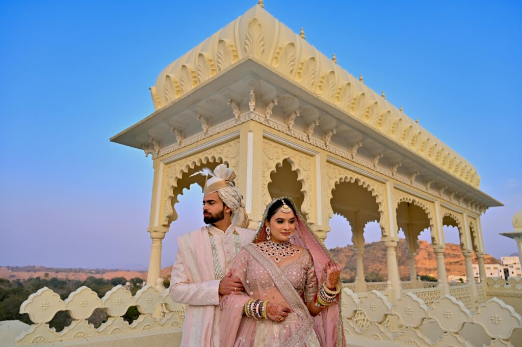 Stunning capture of an Indian bride and groom at a traditional palace setting, exuding elegance and cultural richness.